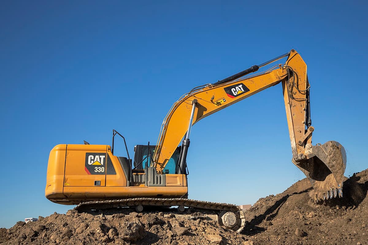 Pelle hydraulique Caterpillar 330 chargeant de la terre sur un chantier