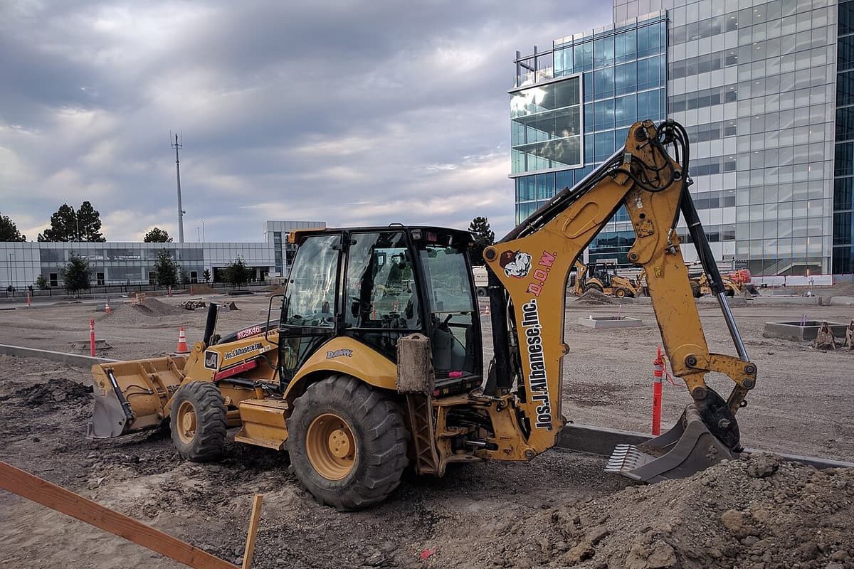 Rétro-chargeuse Caterpillar sur un chantier, bras et godet relevés